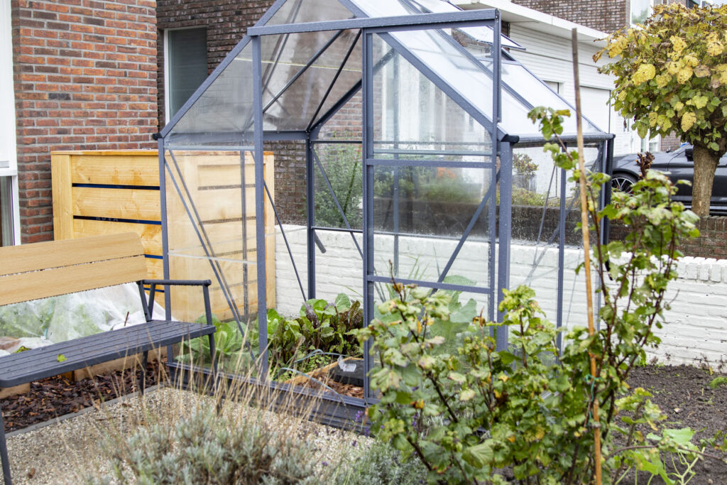 Eetbare voortuin met kas en houten groentebakken in Zwolle