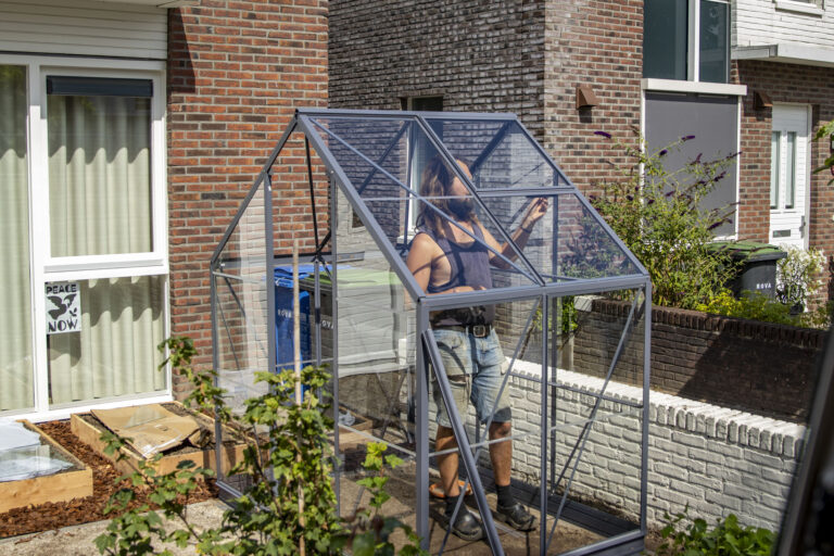 Eetbare voortuin met kas en houten groentebakken in Zwolle